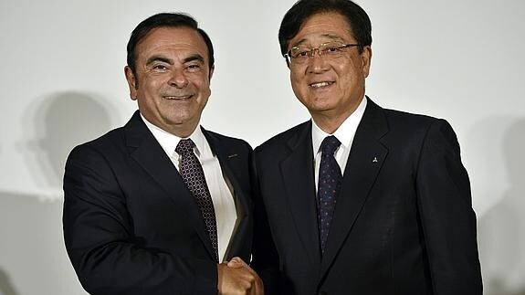 El presidente de Nissan Motor, Carlos Ghosn (i), estrecha la mano del presidente de Mitsubishi Motors, Osamu Masuko.