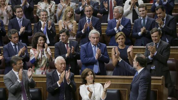 Rajoy recibe desde su escaño el aplauso de la bancada popular tras pronunciar su discurso de investidura. 