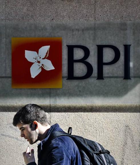 Un hombre pasa por debajo del logo de BPI en Lisboa, Portugal.