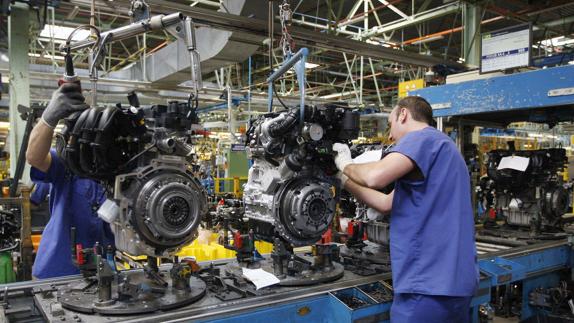 Empleados en una cadena de montaje de vehículos.