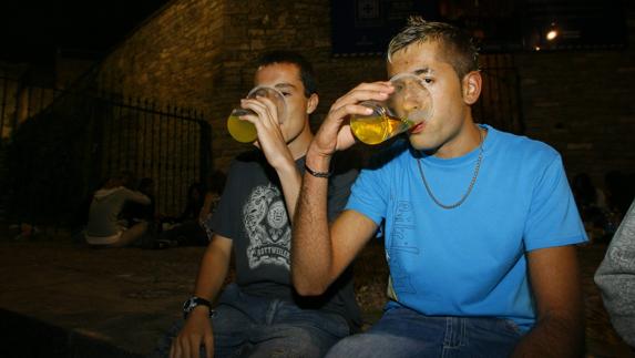 Dos jóvenes consumen alcohol en la calle.
