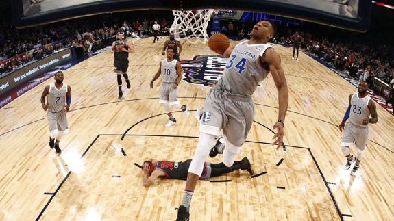 Giannis Antetokounmpo machaca el aro, con Stephen Curry por los suelos. 