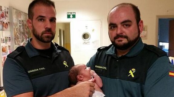 Los agentes de la Guardia Civil sujetan al bebé. 