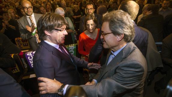 Carles Puigdemont y Artur Mas se saludan.