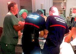 Bomberos, cirujanos y personal sanitario durante la operación para cortar el tubo