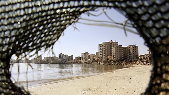 El distrito costero de Famagusta, carente de vida, visto desde el agujero de una malla.