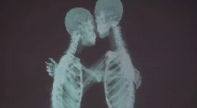Una pareja se besa tras la máquina de rayos x.