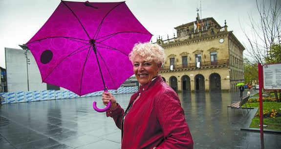 Lucía Garbayo, que ha soportado muchos chaparrones, se protege de la lluvia en la plaza de San Juan.
