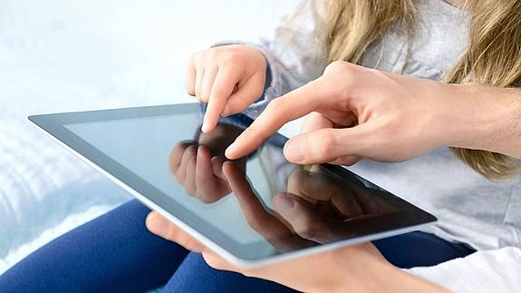 Padre e hija jugando con una tablet.