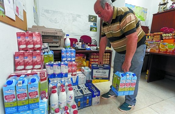 Uno de los organizadores ordena paquetes de leche.