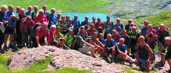 Miembros del grupo de montañeros veteranos posan, en una de sus habituales salidas, ante el ibón de Estanes (Selva de Oza). 