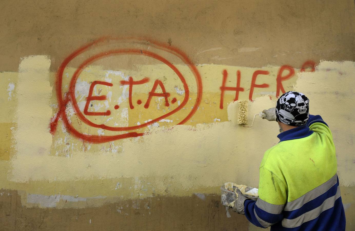 Un trabajador borra una pintada en una pared de Gernika.