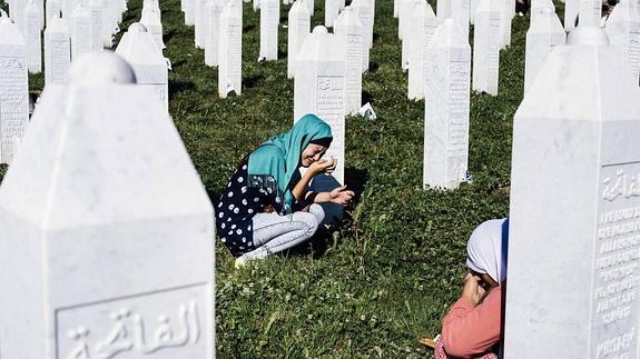 Dos mujeres lloran en un cementerio de Srebenica.