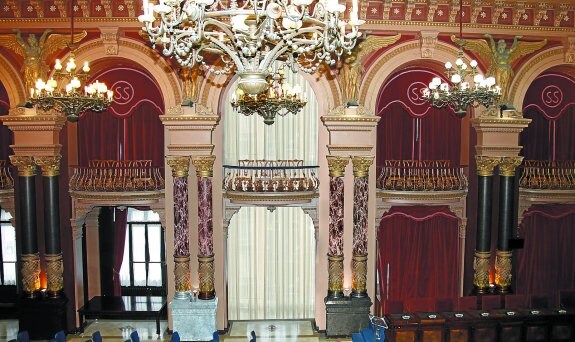 Fotomontaje del estado actual del Salón de Plenos con cortinas y paredes oscuras (laterales de la foto) y la imagen que presentará (centro). 