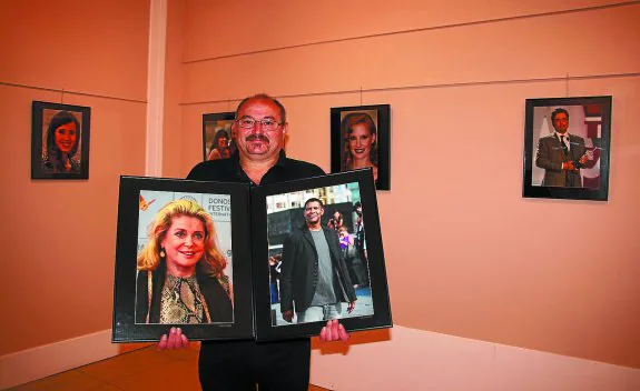 Juan José Quintana porta entre sus manos las fotografías de Catherine Deneuve y Denzel Washington, parte de su exposición. 