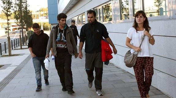 Dos refugiados junto a dos miembros de Cruz Roja, ayer a su salida de comisaría