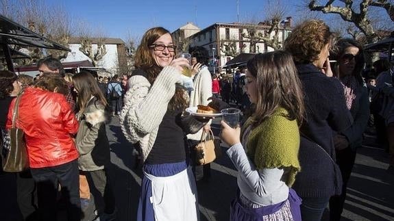 Dos jóvenes degustan la tradicional txistorra con sidra