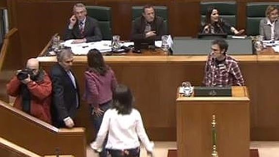 Los parlamentarios del PP abandonan el pleno mientras Julen Arzuaga (EH Bildu) sigue en la tribuna.