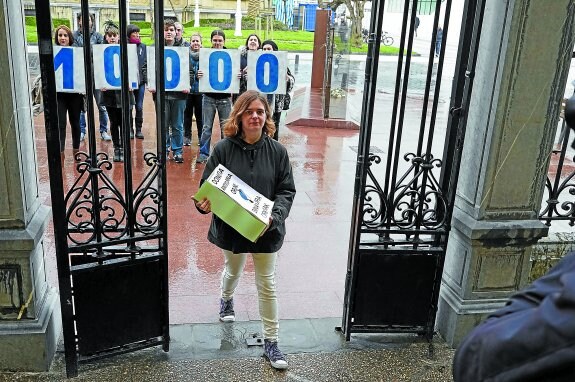 Una representante de Donostia Antitaurina Orain! entrega las 10.000 firmas conseguidas a favor de la consulta.