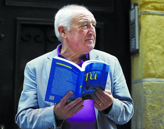 El escritor Anjel Lertxundi, con su nueva obra ayer en la Parte Vieja donostiarra.