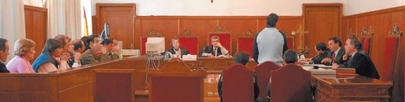Un acusado se levanta de su asiento a la espera de escuchar el veredicto del jurado, situado en un lateral de la sala de vistas.