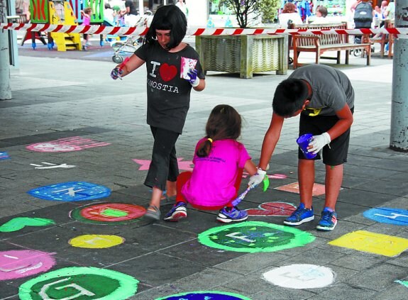 Los niños de los udalekus fueron los encargados de pintar los juegos en el suelo de la plaza Atsegindegi.