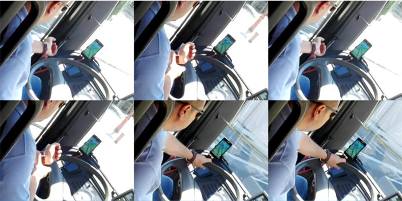 El conductor de autobús junto a su teléfono con la pantalla de Pokémon Go.