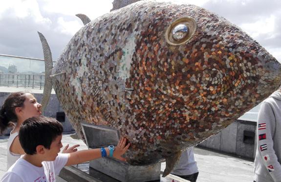 Dos niños observan los desperfectos en la escultura.