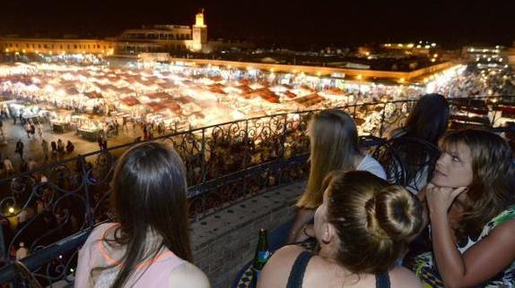 Un grupo de turistas observa desde una terraza la plaza Jemaa el-Fna de Marrakesh.