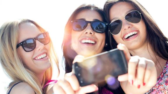 Jóvenes realizan un selfie con su móvil.