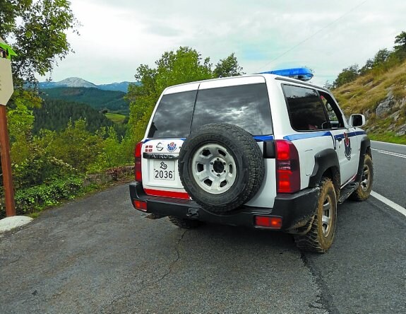 Una patrulla de la Ertzaintza que intervino en los hechos abandona la pista que conduce a la zona de Bellotza. 