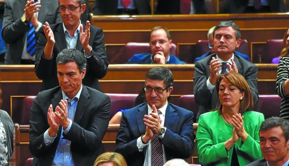 Pedro Sánchez, con Patxi López a su lado y Eduardo Madina detrás, aplaude cariacontecido el discurso del portavoz socialista en la segunda jornada del pleno de investidura.