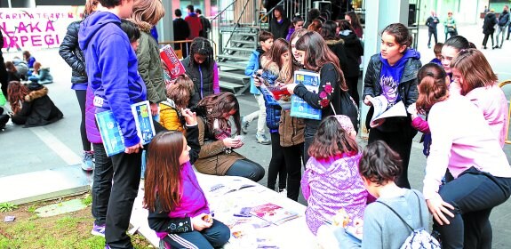 Ointxe Saskibaloi Elkartea. El club morado celebró ayer la presentación de sus álbumes y cromos en la plaza Biteri. 