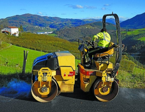 Una apisonadora trabaja en el camino rural que se está rehabilitando en Auzotxiki de Tolosa.