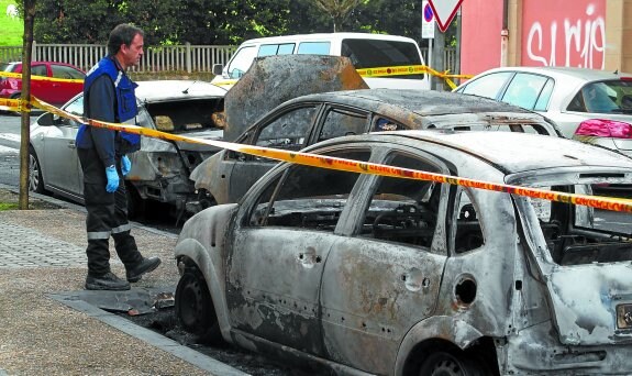 Un responsable de la Unidad de Investigación de Incendios de la Guardia Municipal observa el estado de los automóviles. 