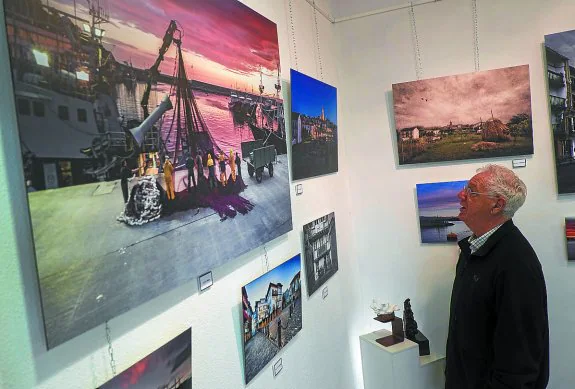 Jokin Arman mira una de las fotografías que compone la exposición de su galería.