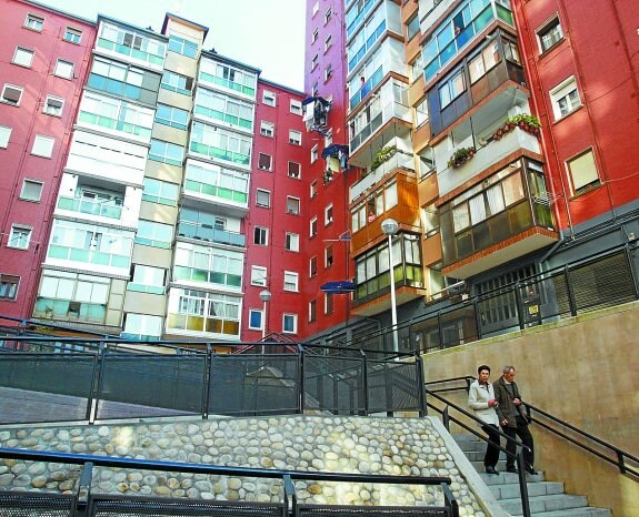 Unos vecinos bajan las escaleras exteriores en un bloque de viviendas situado en una ciudad vasca.