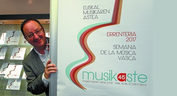 Jon Bagüés, junto al cartel que anuncia la 45 edición de Musikaste, con la imagen sugerente de la guitarra.