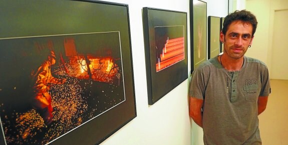 Exposición. Javier Alonso posa delante de algunas de las fotografías de la colección 'Acero' que ya se pueden ver en la casa de cultura. 