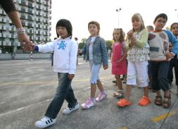 Un grupo de niños sigue a su profesora en el patio del colegio público Amara Berri de Donostia. [ARIZMENDI]