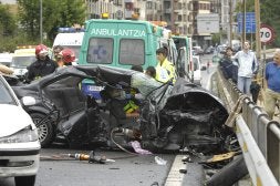 El conductor del BMW es atendido en el interior del vehículo por los sanitarios de Osakidetza, mientras los bomberos ultiman su rescate. /PEDRO MARTINEZ