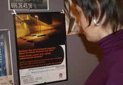 Una joven observa el cartel sobre la presentación del Mapa de la ciudad prohibida. /ARESTI