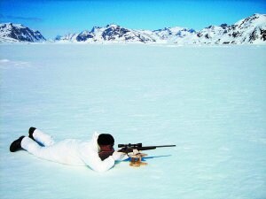 Georg se tumba y desliza su gran tripa por el hielo mientras apunta con el arma a una foca hipotética. /A.I.