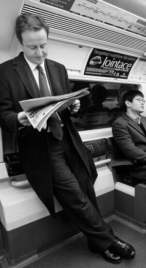 Cameron lee el periódico en el metro. /REUTERS