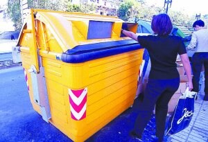 Una mujer deposita basura en el contenedor amarillo. ::                             F. DE LA HERA