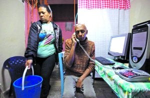 El psicólogo Guillermo Fariñas 'Coco' habla por teléfono en su casa de Santa Clara en presencia de su mujer. ::
REUTERS