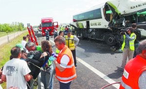 Rescate. Varios sanitarios trasladan tras el accidente a una joven estudiante herida. ::                             EFE