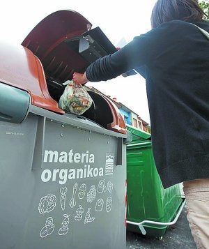 Una vecina mete una bolsa en el contenedor marrón. ::                             LOBO ALTU                            NA