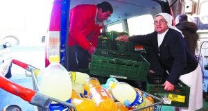 Sor Imelda. La monja carga su furgoneta con la ayuda de un voluntario del Banco de Alimentos de Gipuzkoa. ::                             ARIZMENDI