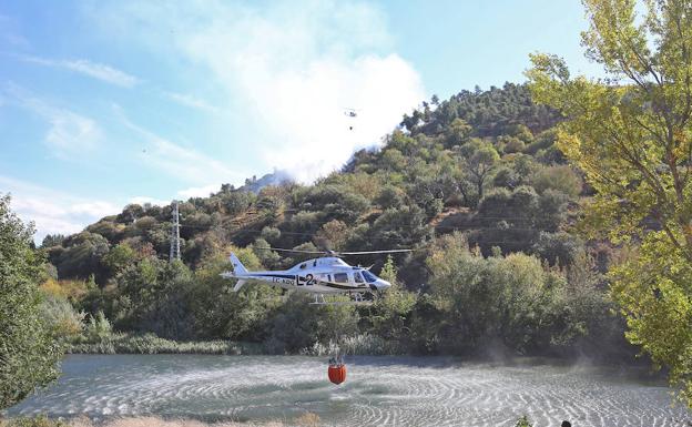 Un helicóptero carga agua en el río Sil para apagar un incendio en el Pajariel.